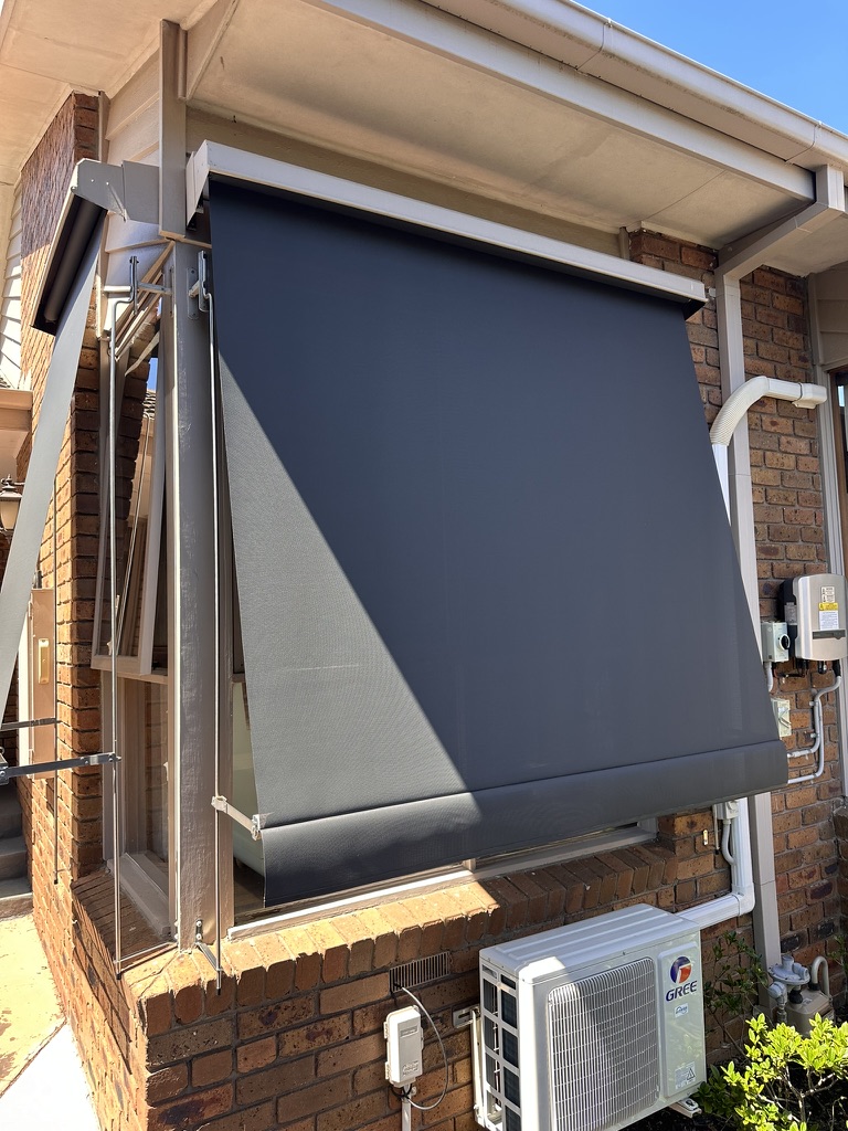 Charcoal auto awning beside a narrow side passage