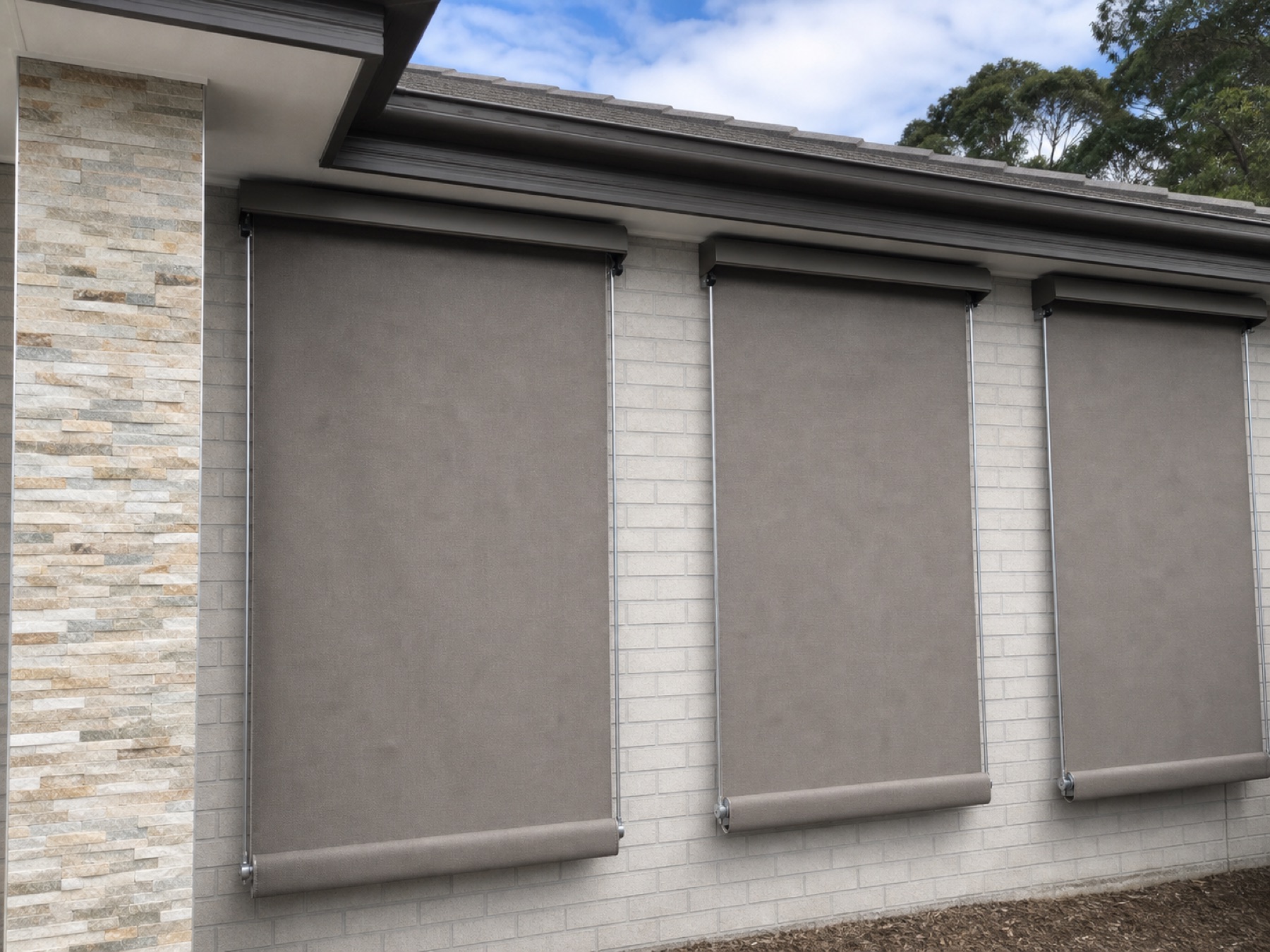 Three fixed guide awnings on a light brick facade