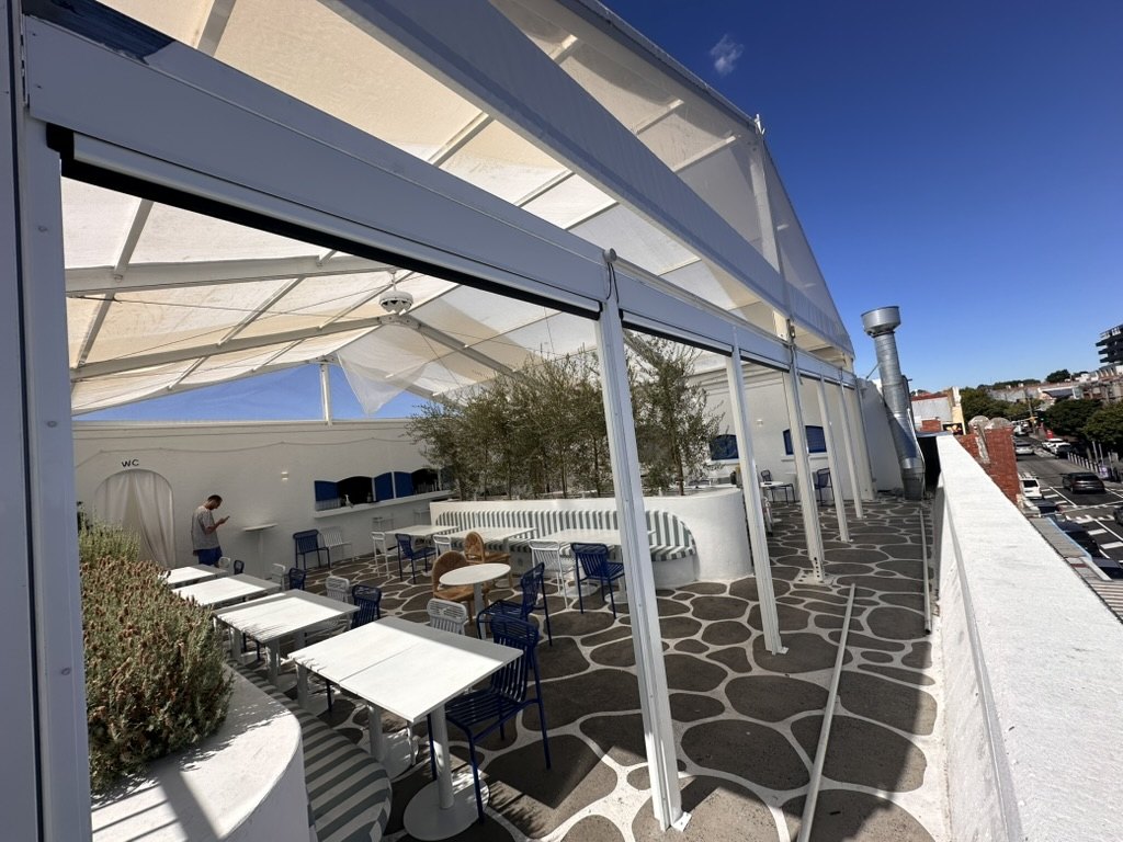 Exterior view of fixed panels and Clear PVC Ziptrak blinds at Olympia Restaurant