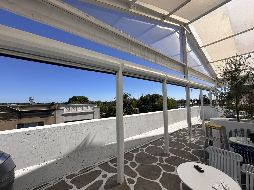Weather proof Clear PVC panels and motorised Ziptrak blinds on a rooftop dining area