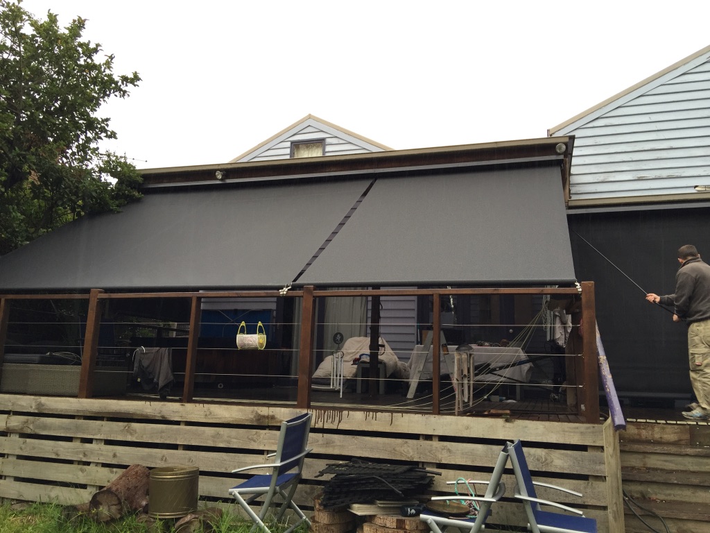 Straight drop blinds held outward on an angle over a residential deck