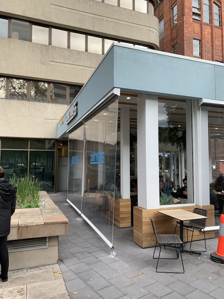 Side view of clear PVC straight drop blinds at a cafe