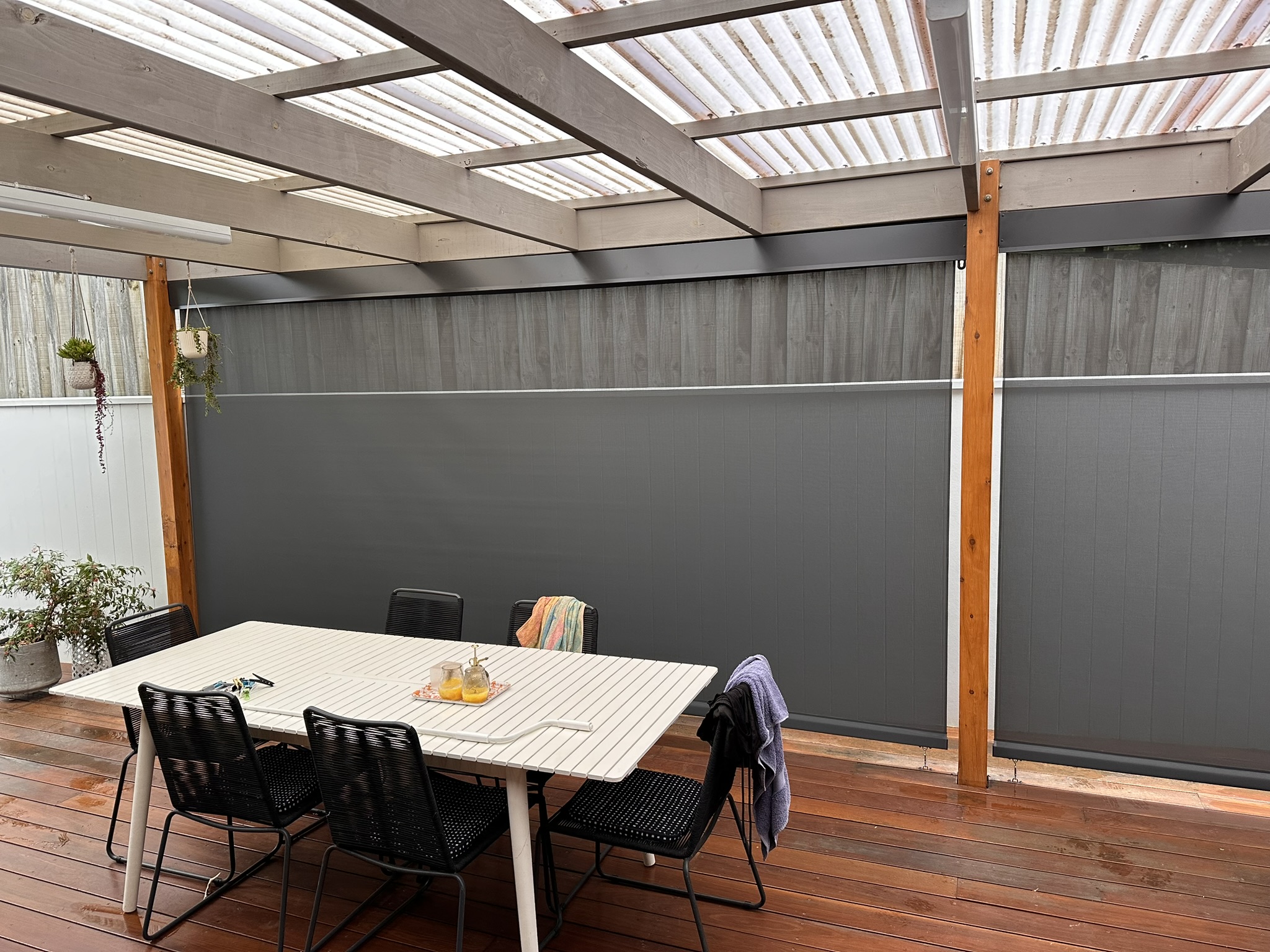 Wide straight drop mesh blinds across a covered outdoor dining area