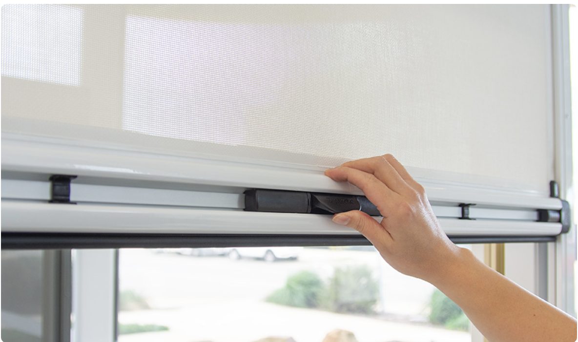 Hand guiding a Ziptrak blind with its spring-balanced centre handle